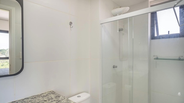 A bathroom with a glass shower enclosure, a toilet, and a marble countertop. - Apartment 400m From Barra Beach Blb1306 (Salvador)