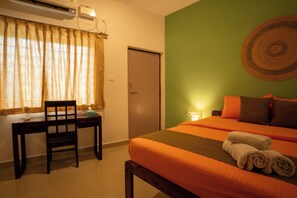 Una habitación de hotel con una cama, un escritorio y una silla.