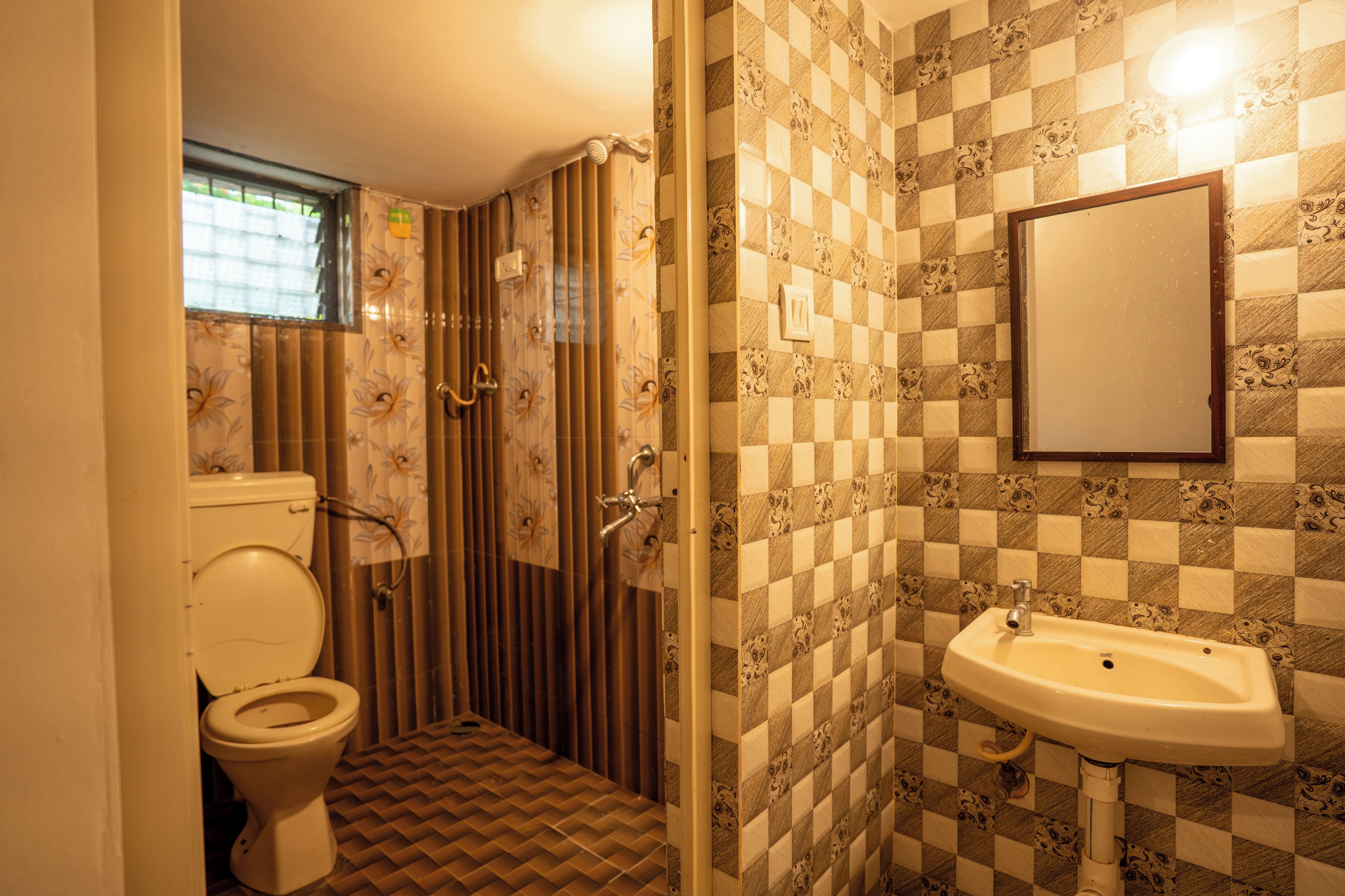A bathroom with a toilet, a shower, and a sink.