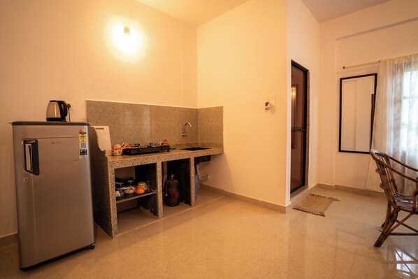 Una cocina compacta con refrigerador, estufa integrada y lavamanos.