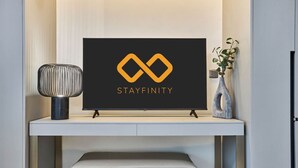 A framed sign with a logo and the word 'STAYFINITY' on a wall-mounted shelf. - Stylish Modern Studio | MAG 910, Meydan Community (Dubai)
