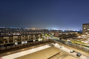 A hotel complex with multiple buildings, parking areas, and a view of the cityscape at night. - Stylish Modern Studio | MAG 910, Meydan Community (Dubai)