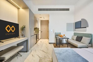 Ein Hotelzimmer mit Bett, Schreibtisch, Fernseher, einer Sitzecke und einem Essbereich.