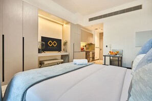 Ein Hotelzimmer mit einem Bett, einem Schreibtisch, einer Küchenzeile und einem Badezimmer.