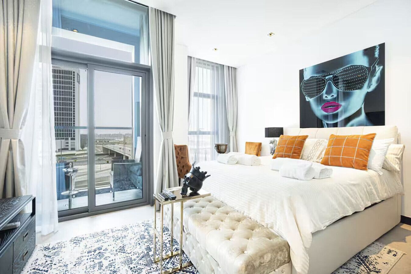 Een moderne hotelkamer met een groot bed, uitzicht op de stad en een ruim raam.