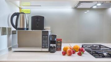 A modern kitchen with a microwave, coffee maker, and a gas stove.