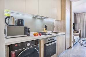A modern kitchen with a built-in microwave, coffee maker, and a range of appliances including a dishwasher and oven.