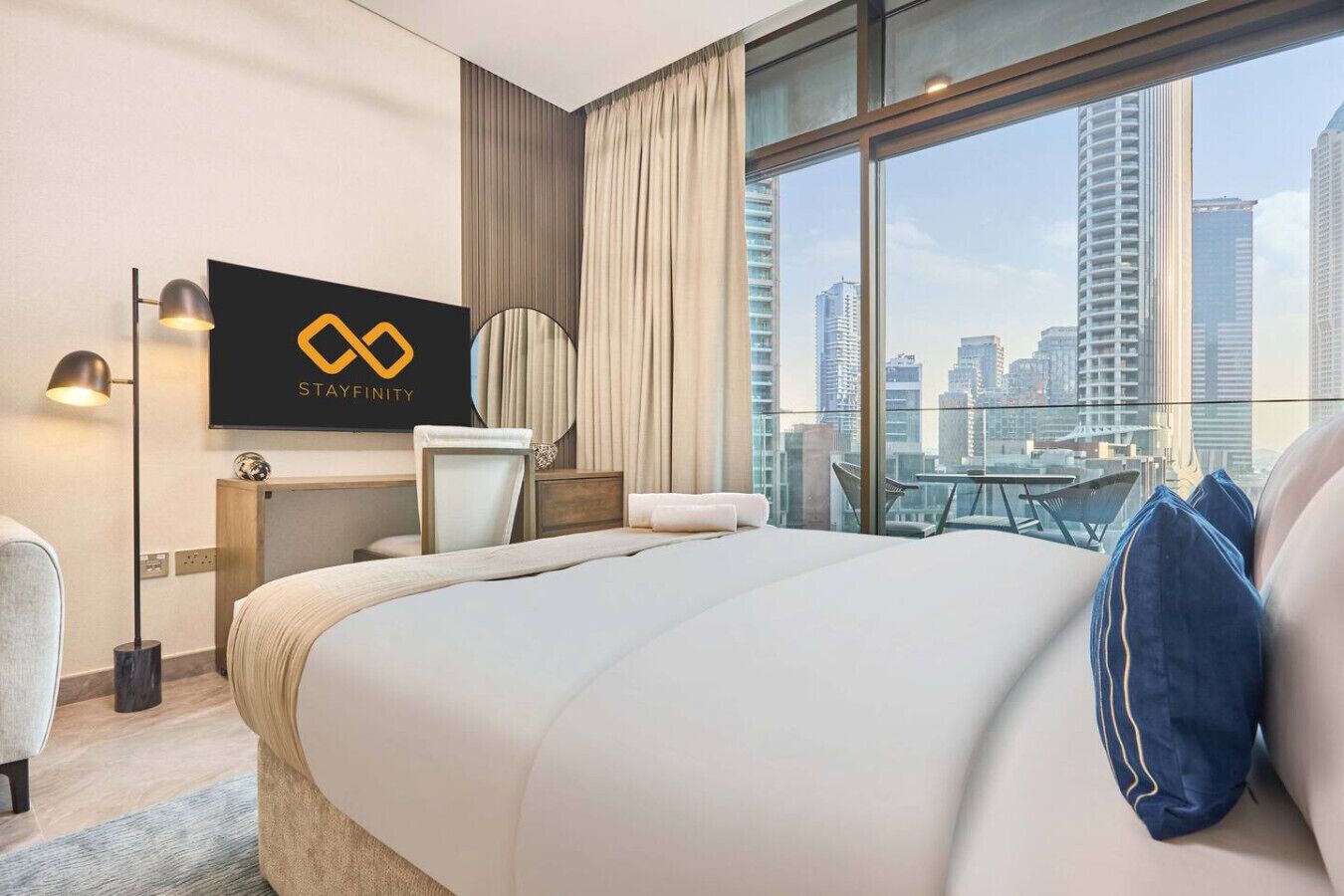 Une chambre d’hôtel avec un grand lit, un bureau, une chaise, une télévision et une vue sur la ville.