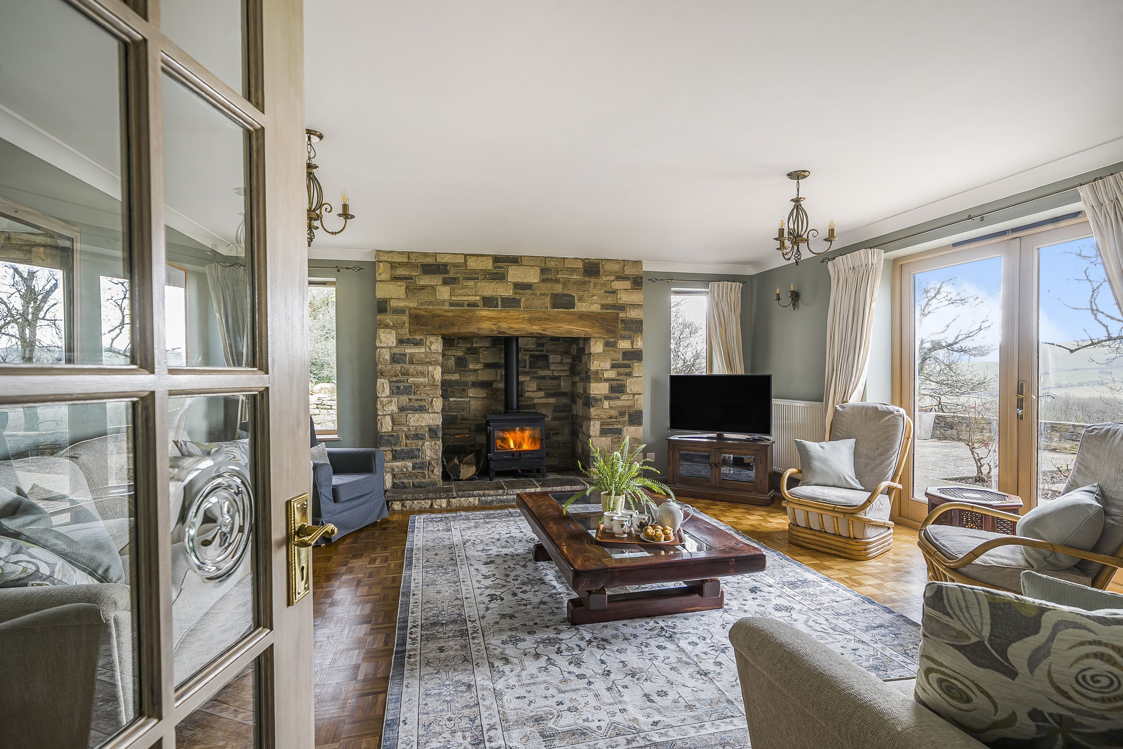 Una sala de estar acogedora con chimenea de piedra, asientos cómodos y un televisor.