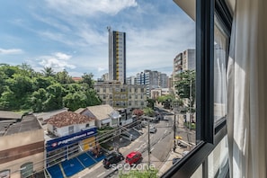 A cityscape with a tall building, a pharmacy, and a street with cars. - Apt 400m From Beach w/ Pool in the Bldg. Blb0402 (Salvador)