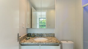 Un bagno con un piano di lavoro in granito, un lavabo, un water e uno specchio grande.