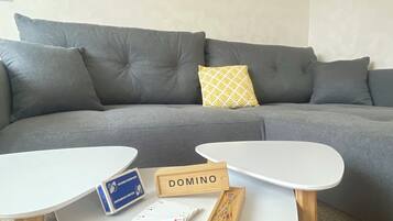 A living room with a grey sofa, a white coffee table, and a painting on the wall.