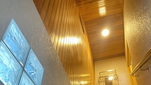 A staircase with a wooden finish and a textured wall.
