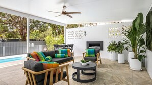 An outdoor patio area with a pool, seating, and potted plants. - Sandy Toes – Lux Retreat with Heated Pool (Nelson Bay)