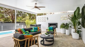 An outdoor patio area with a pool, seating, and potted plants. - Sandy Toes – Lux Retreat with Heated Pool (Nelson Bay)