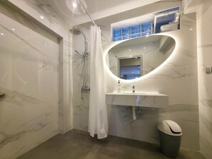 A modern bathroom with a shower, a sink, and a mirror. - Odyssey Superior Junior Suite (Paralia)