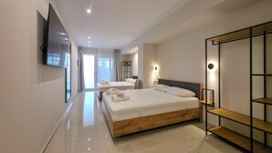 Ein modernes Hotelzimmer mit einem großen Bett, einem an der Wand befestigten Fernseher und einer holzverkleideten Regaleinheit.