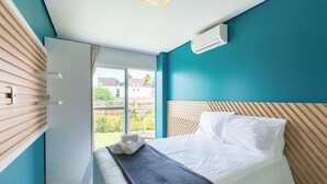 Une chambre d’hôtel avec un lit, une fenêtre et un appareil de climatisation.