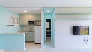 Une cuisine compacte équipée d’un four à micro-ondes, d’un réfrigérateur et d’un évier.
