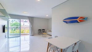 Un intérieur moderne comprenant un coin repas, un canapé et une vue à travers une porte vitrée.