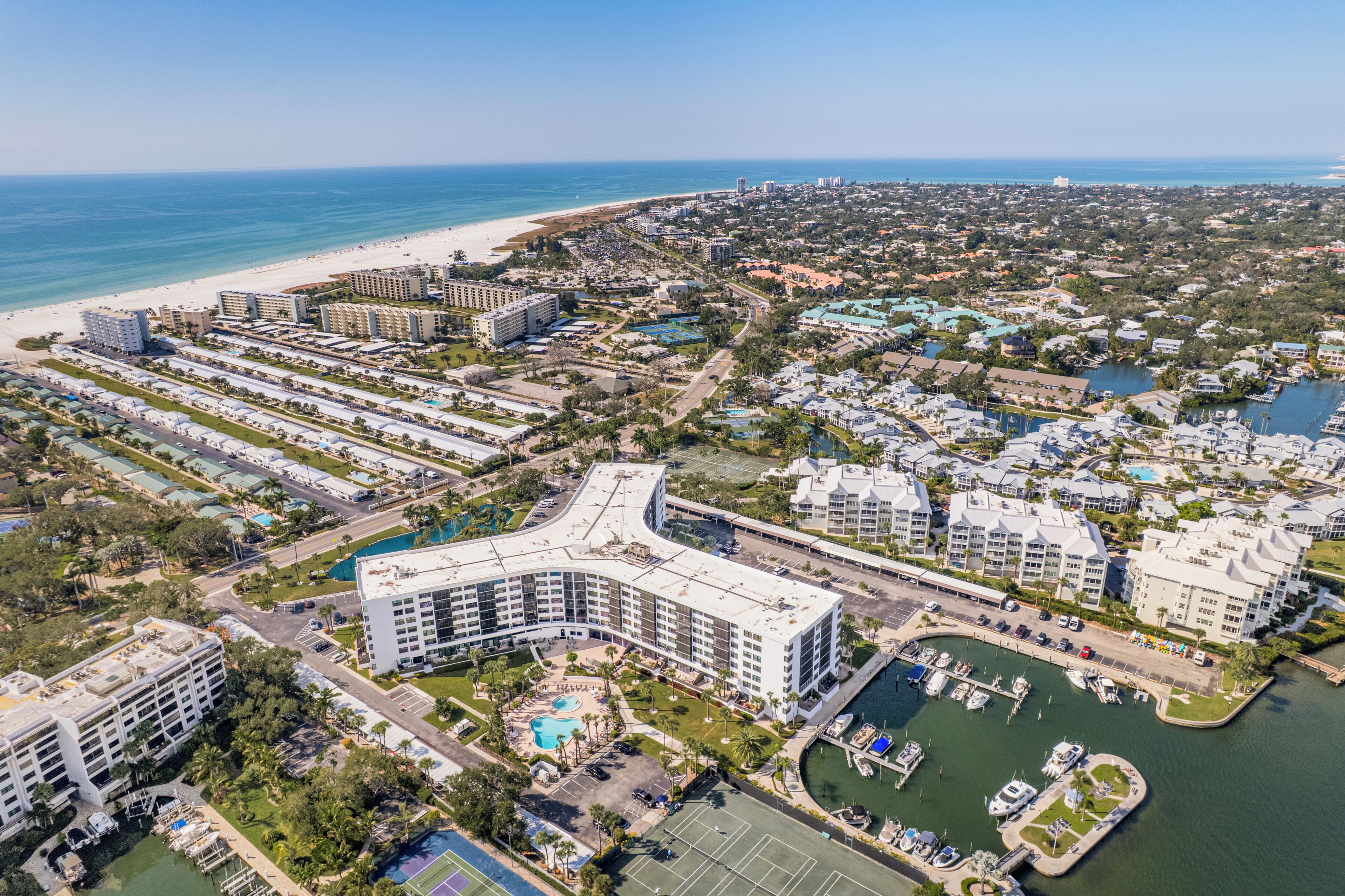 A coastal resort area with multiple hotel buildings, a beach, and a marina.