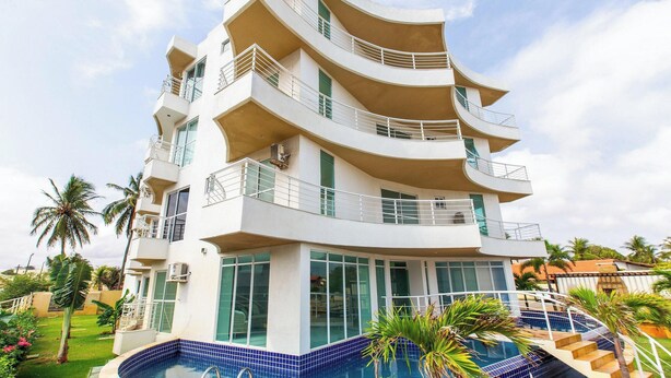 A multi-story hotel with balconies, a swimming pool, and tropical landscaping. - Ap in Condo w/ Pool 1 Block From the Beach Kvi0307 (Caucaia)