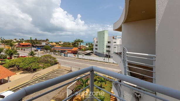 Uma varanda com vista para a rua, edifícios e um céu limpo.