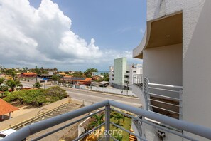 Un balcón con vista a una calle, edificios y un cielo despejado.