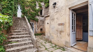 A stone staircase leading to a building with a door and a sign.
