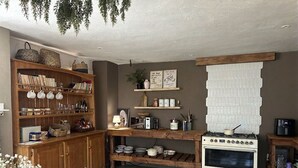 Una cucina con mobili in legno, un fornello e diversi utensili da cucina.