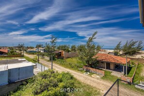 Zona residencial con casas, un camino de tierra y cielo azul despejado.