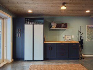 A kitchen with a double-door refrigerator, wooden cabinets, a wooden countertop, and a hanging umbrella. - Evergreen Overlook—elevated Catskills cabin—cedar hot tub, sauna, gym, rec room (Parksville)