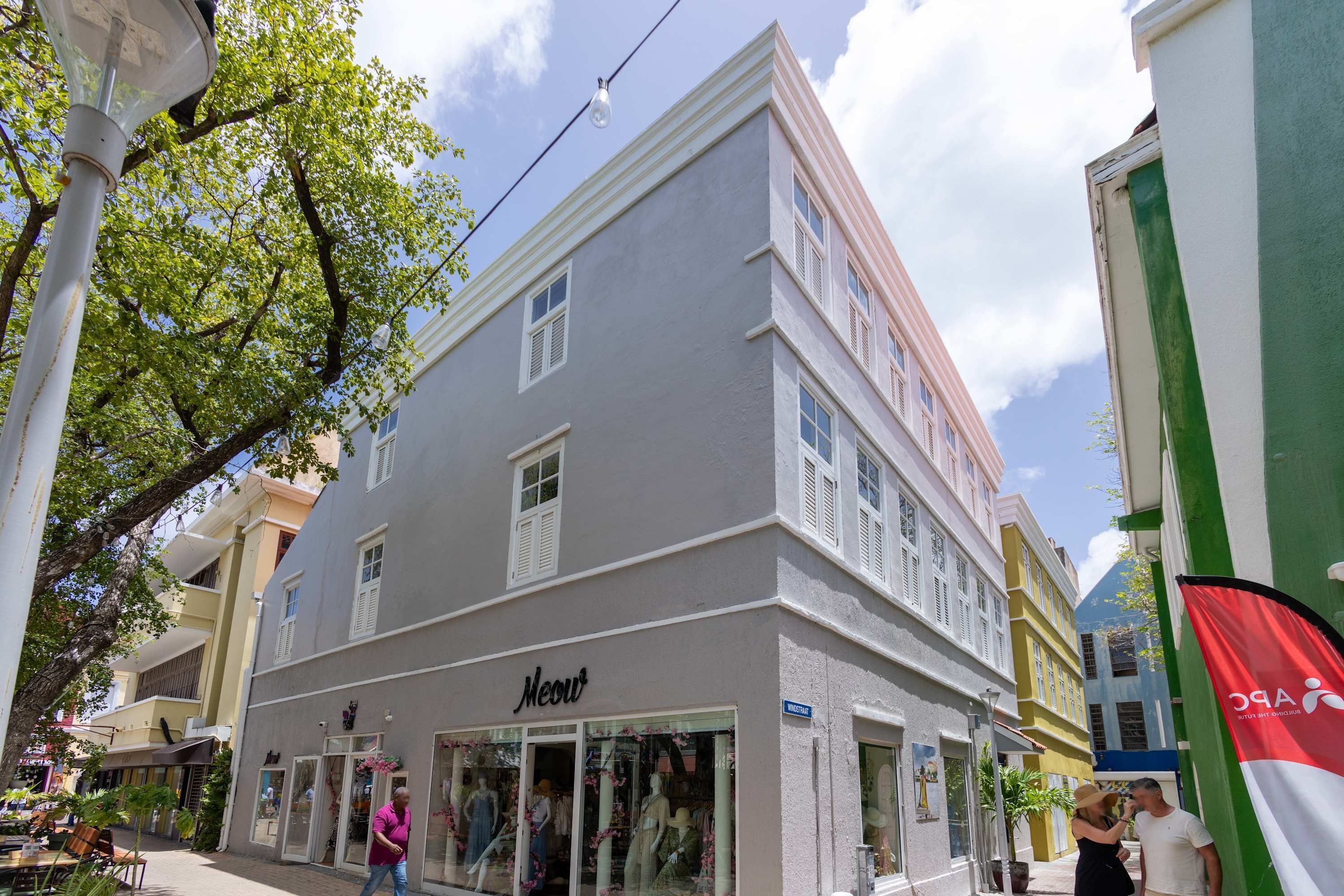 A building with a storefront labeled 'Meow' and a street sign indicating 'WINDSTRAT.'