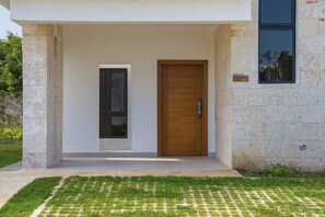 Ein modernes Haus mit Holztür und kleinem Fenster.