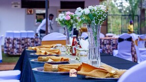 Una mesa dispuesta con servilletas dobladas, cristalería y una botella, probablemente para un evento gastronómico.