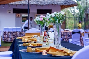 Una mesa dispuesta con servilletas dobladas, cristalería y una botella, probablemente para un evento gastronómico.