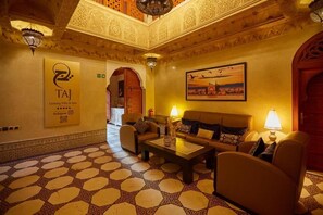 A lobby with a patterned floor, a sofa set, a coffee table, and a painting on the wall. - Villa Taj Sofia & Spa (Marrakech)