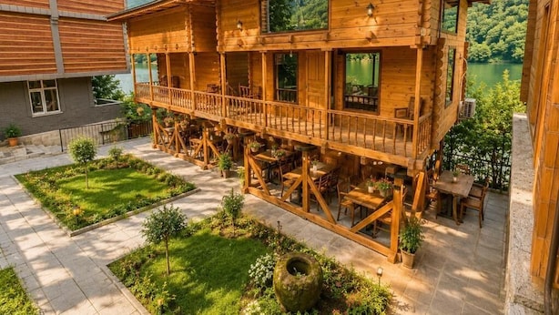 A wooden building with a balcony and outdoor seating area. - Buneba Resort (Borçka)
