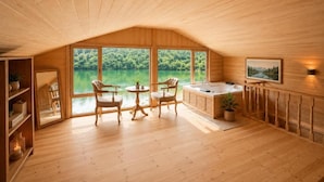 A wooden interior with a large window, a bathtub, and a seating area. - Buneba Resort (Borçka)