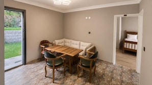 A room with a dining table and chairs, a sofa, a radiator, and a bed. - Buneba Resort (Borçka)