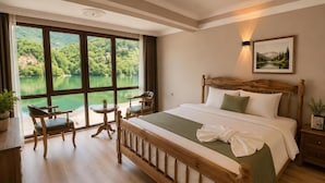 A bedroom with a large window, a bed, a bedside table, a chair, and a small table. - Buneba Resort (Borçka)