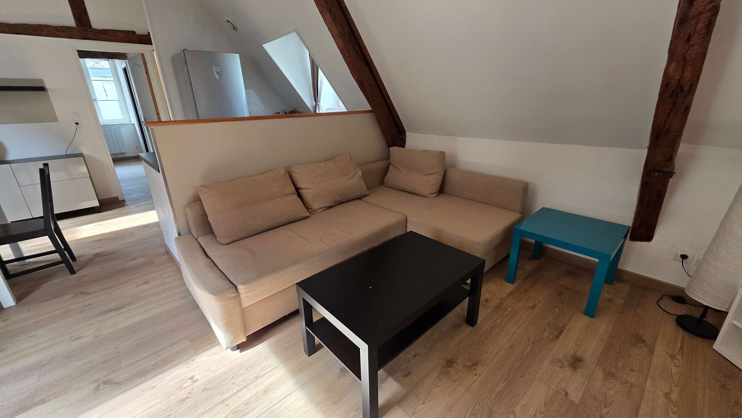 A modern living room with a sofa, a coffee table, and a small table.