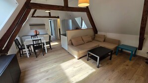 A loft-style living space with a dining area, a sofa, and a small table. - T2 l Gant Devant la Mairie - Calme - Centre (Arras)