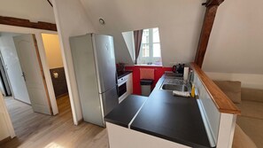 Une cuisine compacte équipée d’un réfrigérateur, d’un four et d’un évier.
