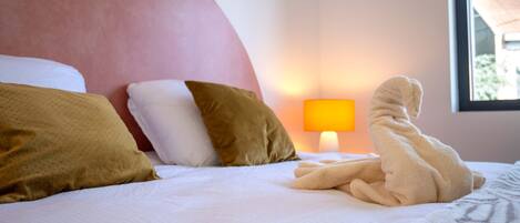 Une chambre d’hôtel avec un lit, des oreillers, une lampe et une fenêtre.