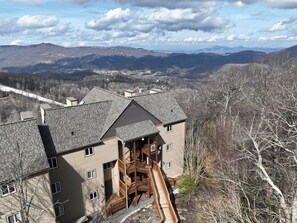 Ein mehrgeschossiges Gebäude mit einer zentralen Treppe, umgeben von einer gebirgigen Landschaft.