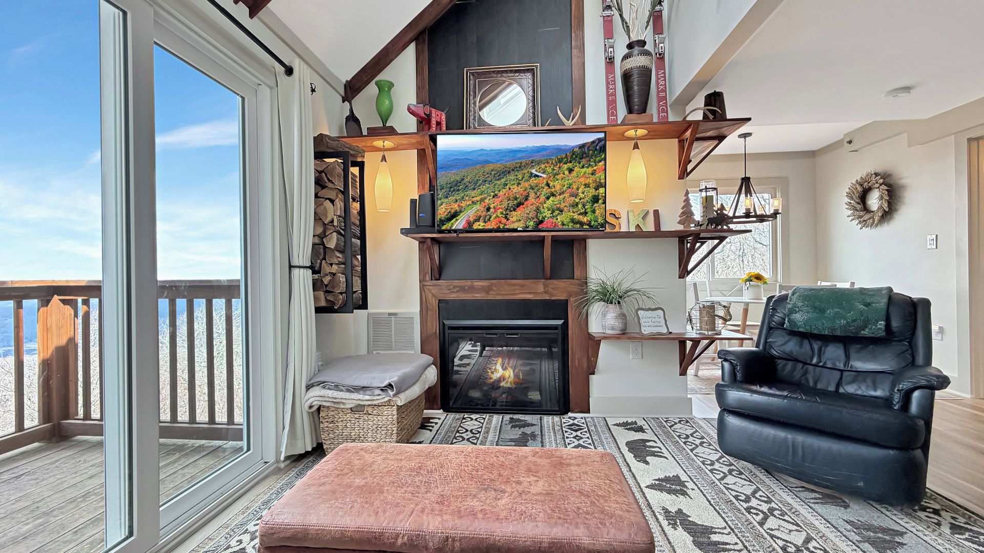 A cozy living room with a fireplace, a television, and a black leather chair.