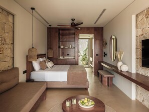 Une chambre moderne comprenant un lit, un coin salon, une table à manger et une cuisine intégrée.