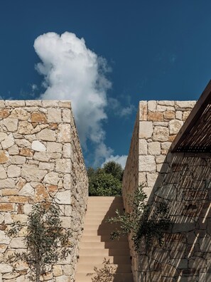 A stone staircase leading up to a building with a wooden roof. - Filema Suites (Xirokampi)