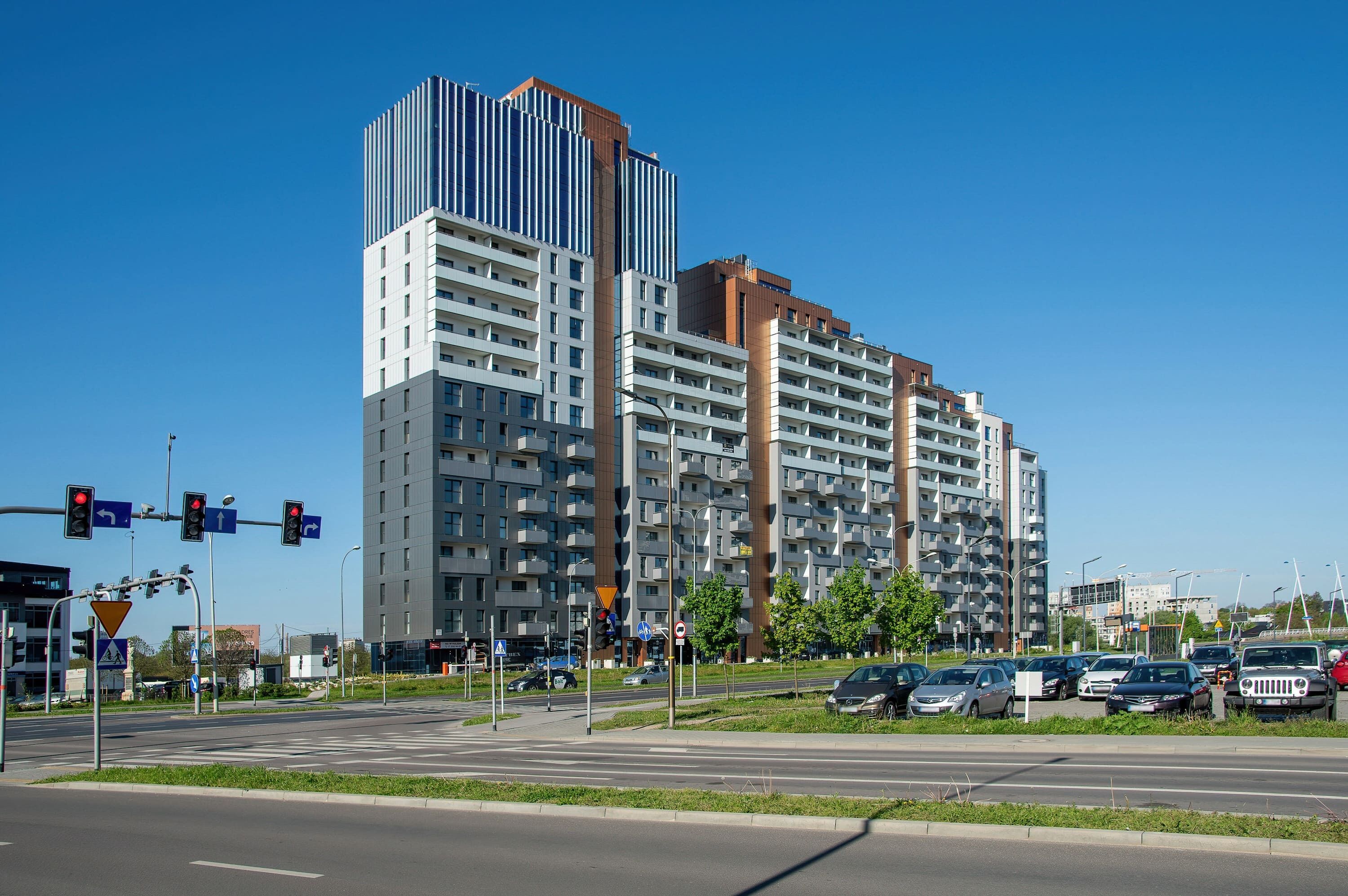 Un edificio residencial de varios pisos con un diseño arquitectónico moderno, que presenta balcones y una combinación de diseños de ventanas.